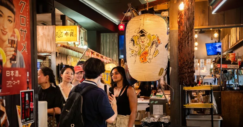 提灯や古いポスターが飾られた小さなバーが並ぶ渋谷の細い路地と、店内の客
